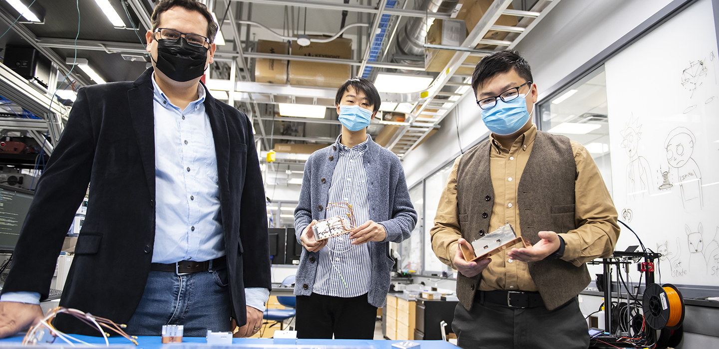 Michael Hatridge with two students in lab