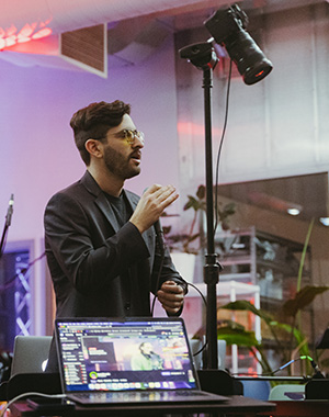 Maggiore talks while setting up lights. A laptop is on in the foreground.