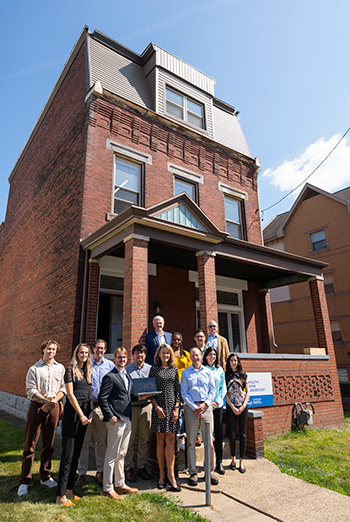 A group of people stand outside the Healthy Home Lab