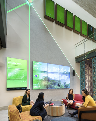 Two-floor image of Global Hub, showing students sitting in the lower floor with a giant Experience Screen showing images of Brazil