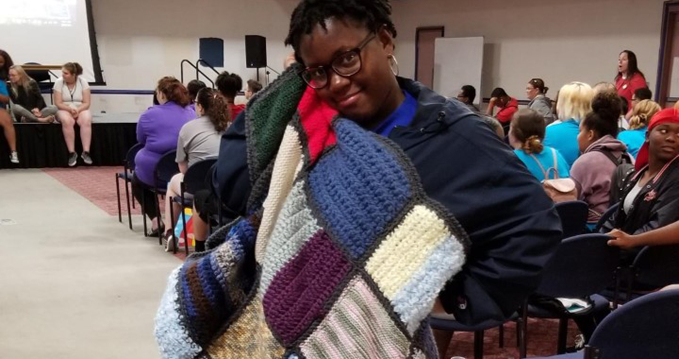 a young woman snuggling a blanket 