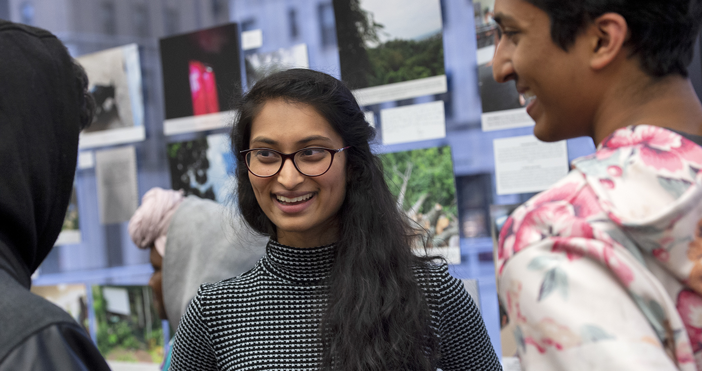 Prachi talking to two people in front of photography