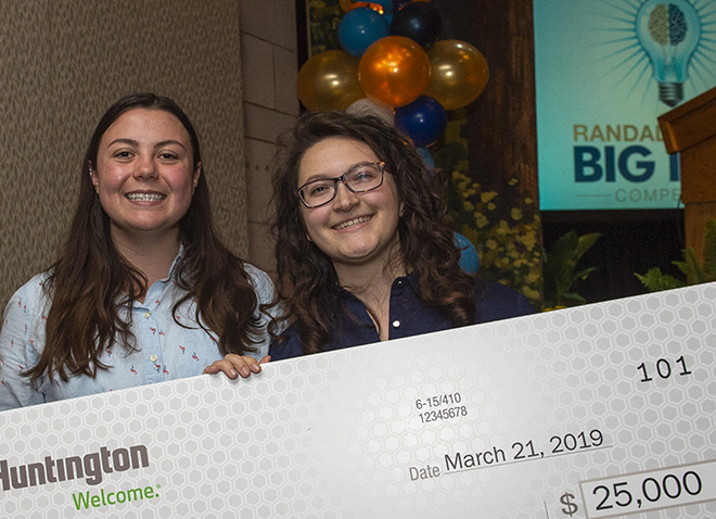 Undergrads Lauren Yocum and Emily Siegel holding giant check for $25,000