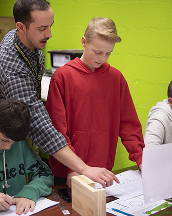 Mannarino and a student in a red hoodie looking at documents on a table