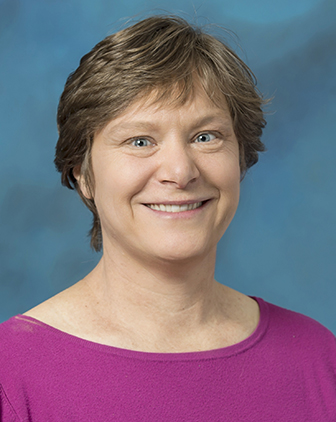 woman in a pink shirt in front of a blue background