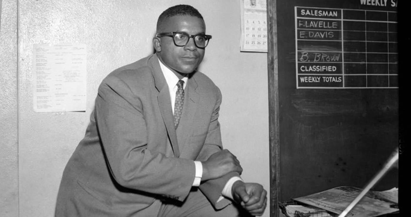 George Barbour in a black and white photograph next to a blackboard