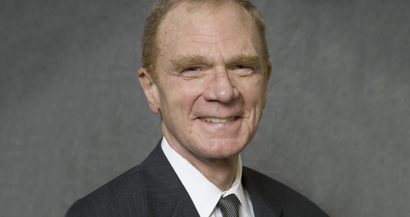 Braun in a suit in front of a gray background