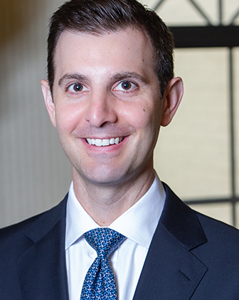 A man in a blue suit jacket, shirt and tie