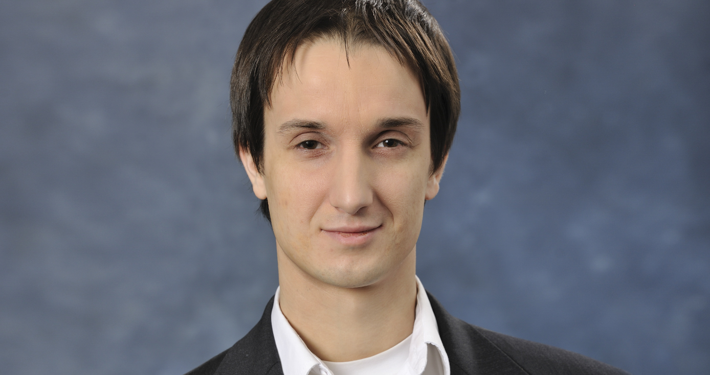 Chris Wilmer headshot against a blue-gray background.