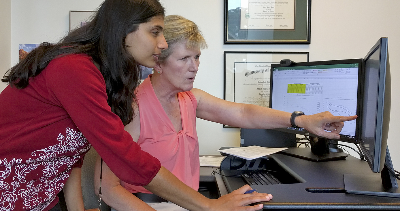 Khoja and Freburger at a computer