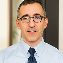 A man in a light blue dress shirt and tie