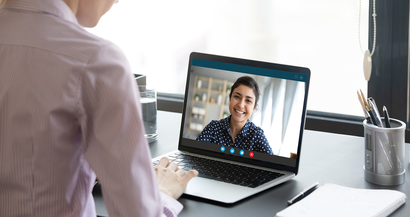 a person in a blue and white polka dot shirt on a laptop screen