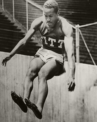 black and white photo of Douglas in a Pitt jersey leaping in the air