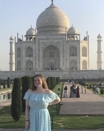 Molly Brandenburg pictured in blue dress with the Taj Mahal in Agra, India, in the background. 