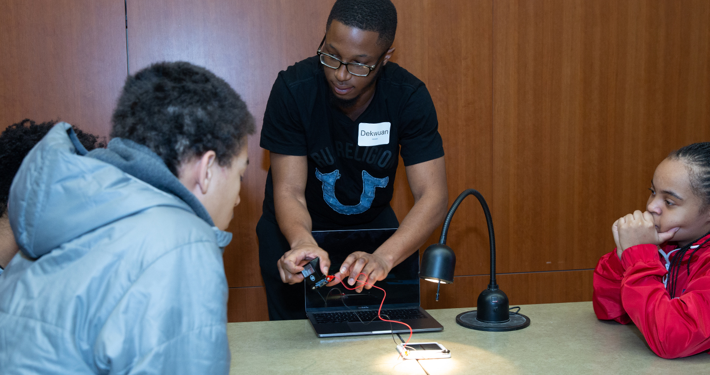 An instructor displays how to use a device to two students