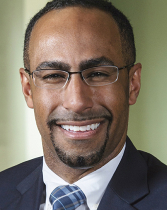 A man in a dark suit jacket and white dress shirt