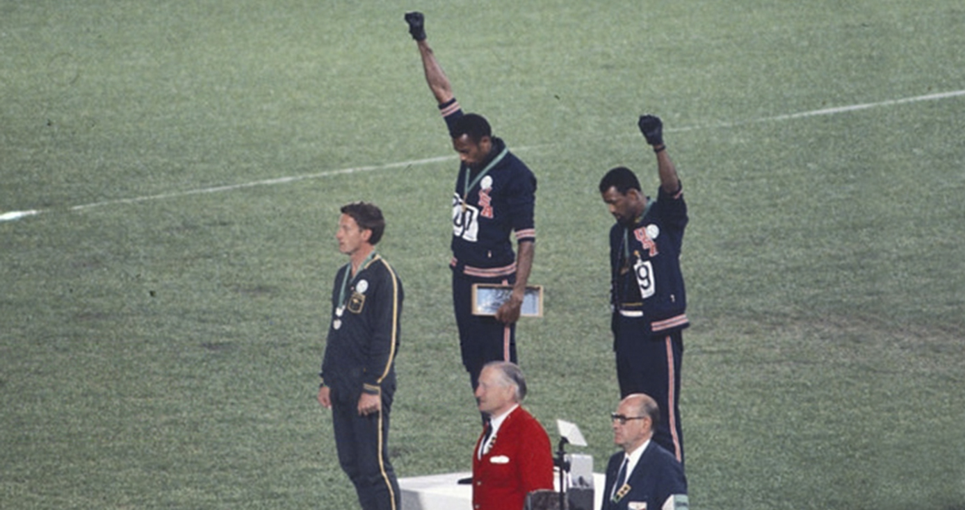 Tommy Smith and John Carlos on a podium holding their fists in the air