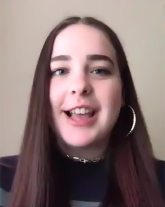 a young woman in a dark shirt and hoop earrings