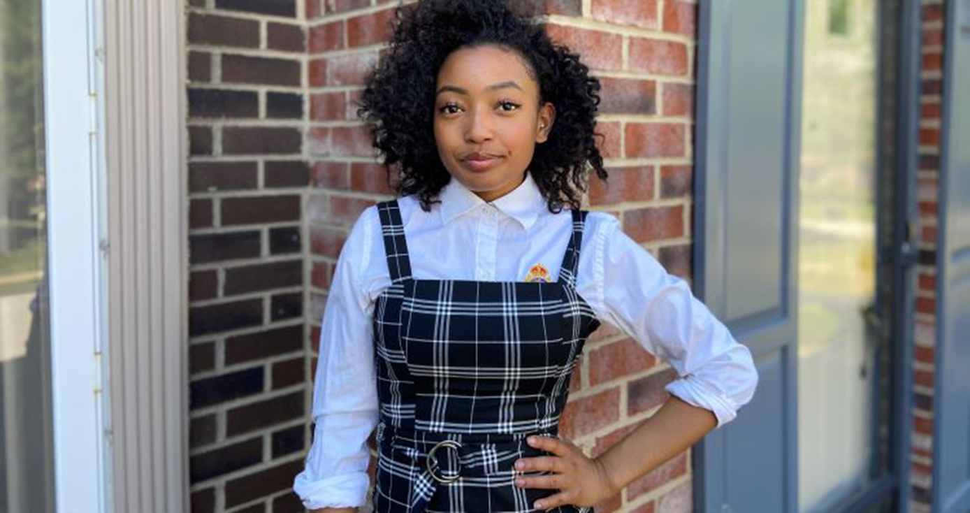 Kyley Coleman in black striped overalls and a white collared shirt underneath