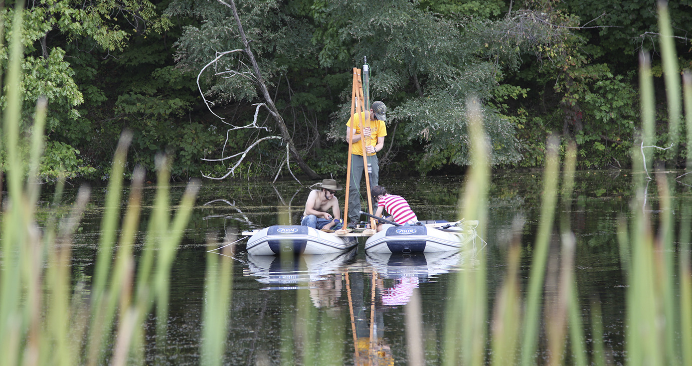 people on a raft in a lake taking a sample