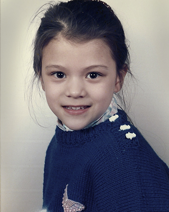 Libertus as a child, wearing a navy blue sweater