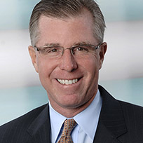 Richards in a dark suit, blue shirt, orange-ish tie