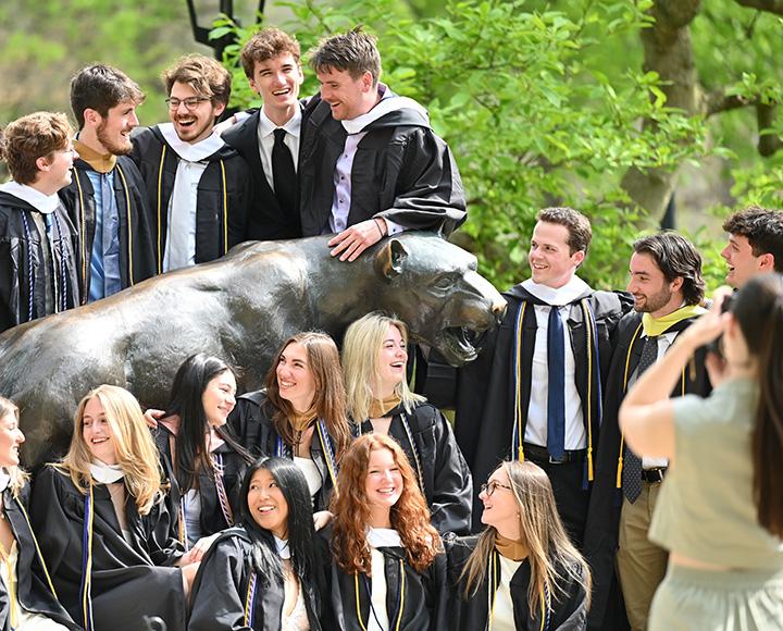 Graduating students surronding the Pitt Panther statue