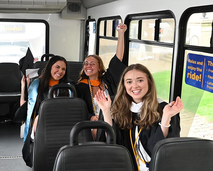 Graduating seniors cheering on a bus
