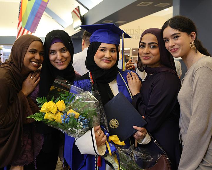 Four friends surround a graduate