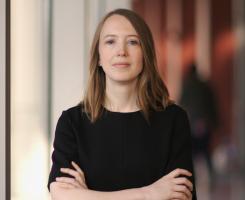 Leah Byrne in black shirt, looking at camera with arms crossed