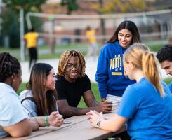 Pitt-Bradford students talk around an outdoor table