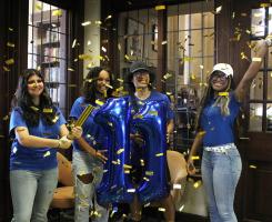 Confettis flies around students holding an eleven balloon