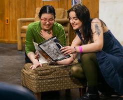 Two student actors look at a magazine