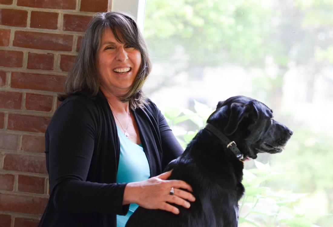 A woman pets her dog.