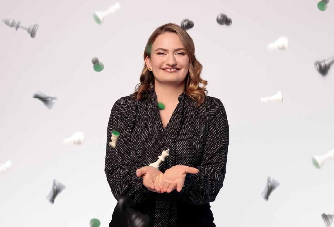 Woman tosses chess pieces into the air.