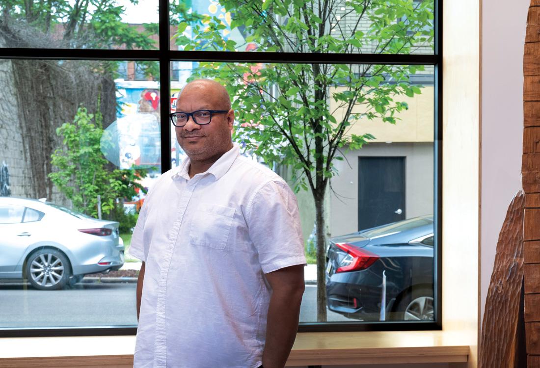 Man with hands in pockets standing in front of a window.