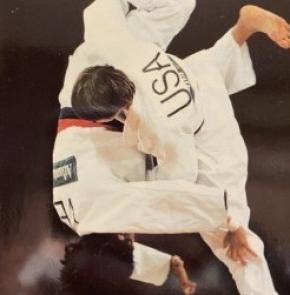 Judo athlete throwing opponent to the mat.