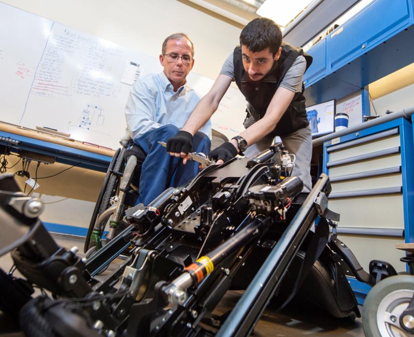 two people working on a wheelchair