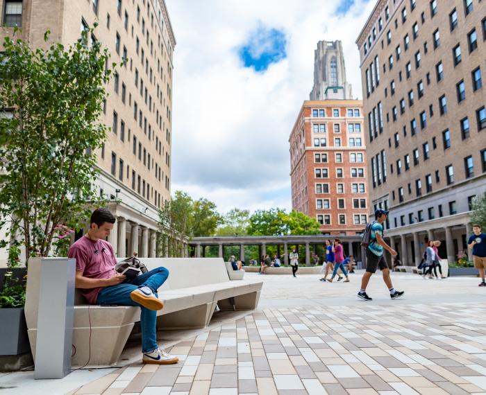 Students sitting and walking around the Schenley Quadrangle