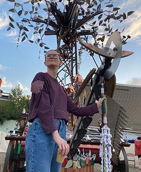 Felker holds part of an outdoor tree sculpture