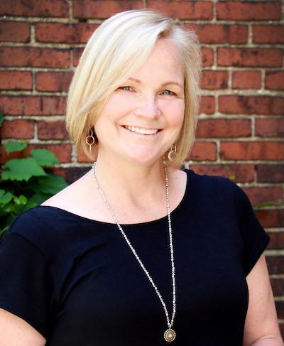 Woman standing in front of brick wall