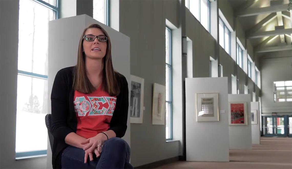 A person sits for an interview in an art gallery